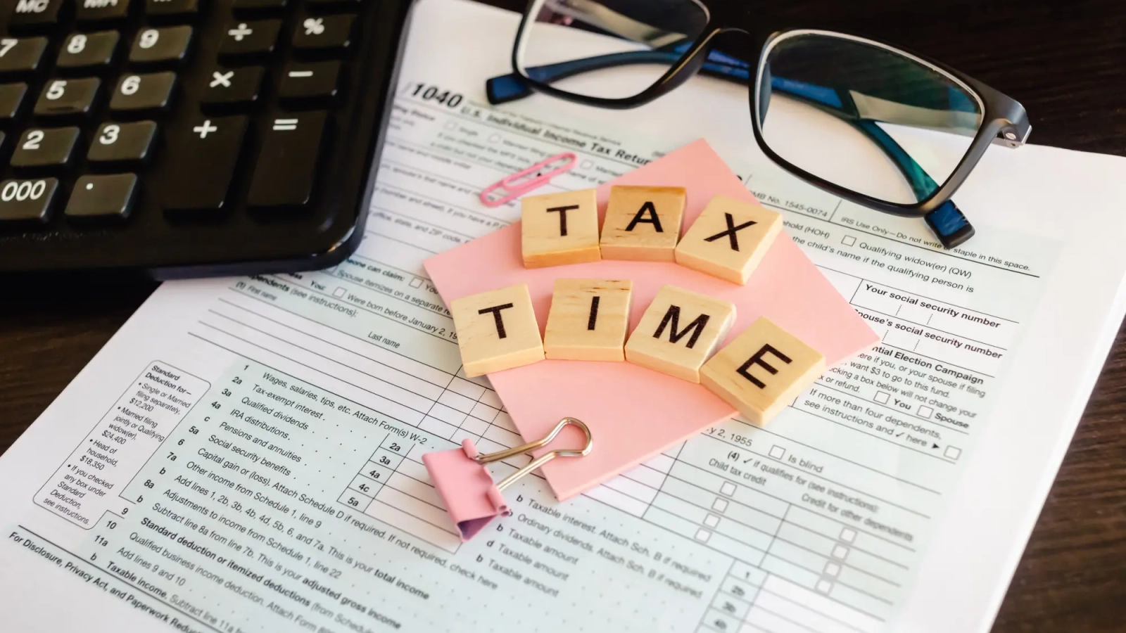 tax-time-wooden-letters-tax-form-with-sticker-glasses-calculator_130153-485