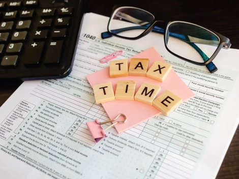 tax-time-wooden-letters-tax-form-with-sticker-glasses-calculator_130153-485